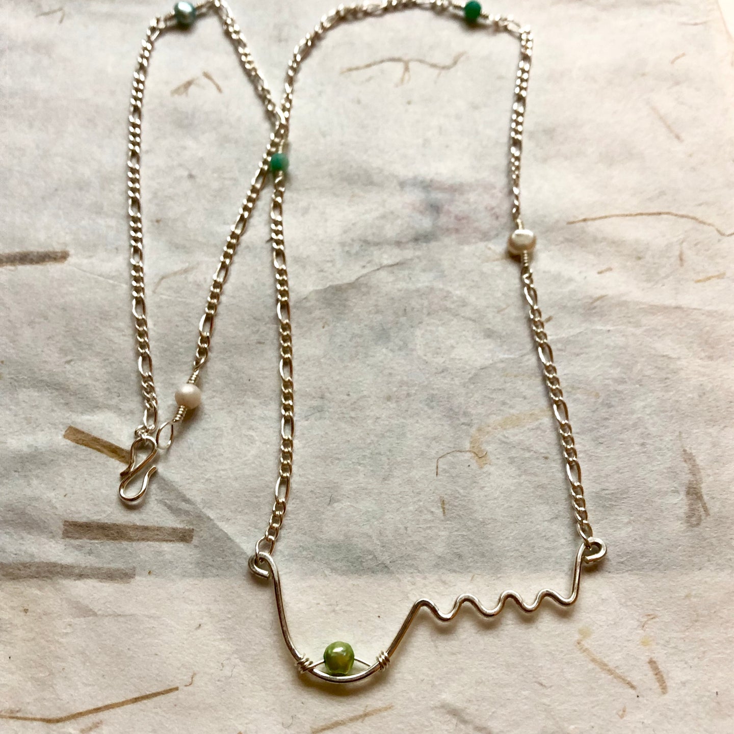'Femme' halskæde Ltd i sølv med et bryst og grøn perle